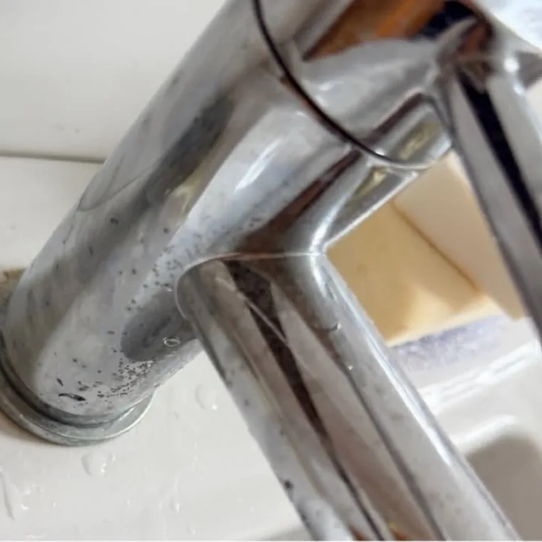 Bath tap before cleaning, with limescale and grime around the base