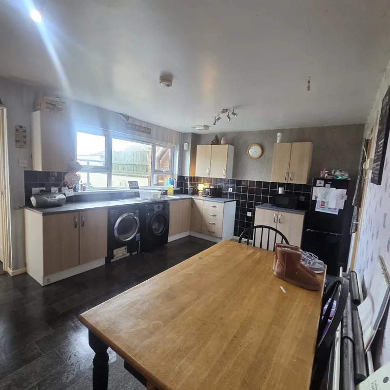 The same kitchen after a full clean and clearance, floor clear and surfaces wiped down