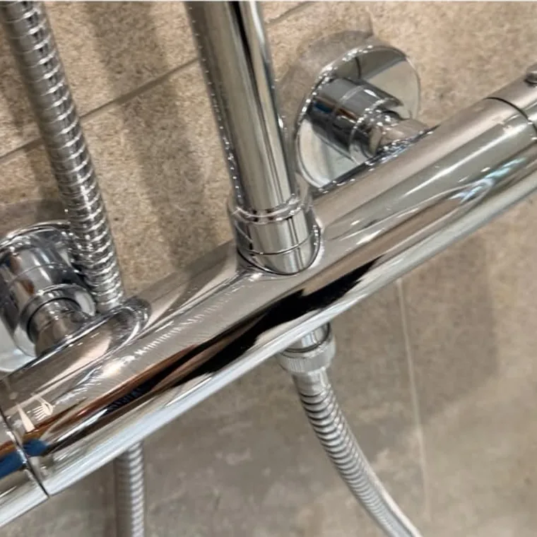 The same shower fittings after cleaning, gleaming chrome