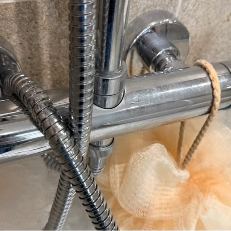 Shower fittings before cleaning, dulled by limescale