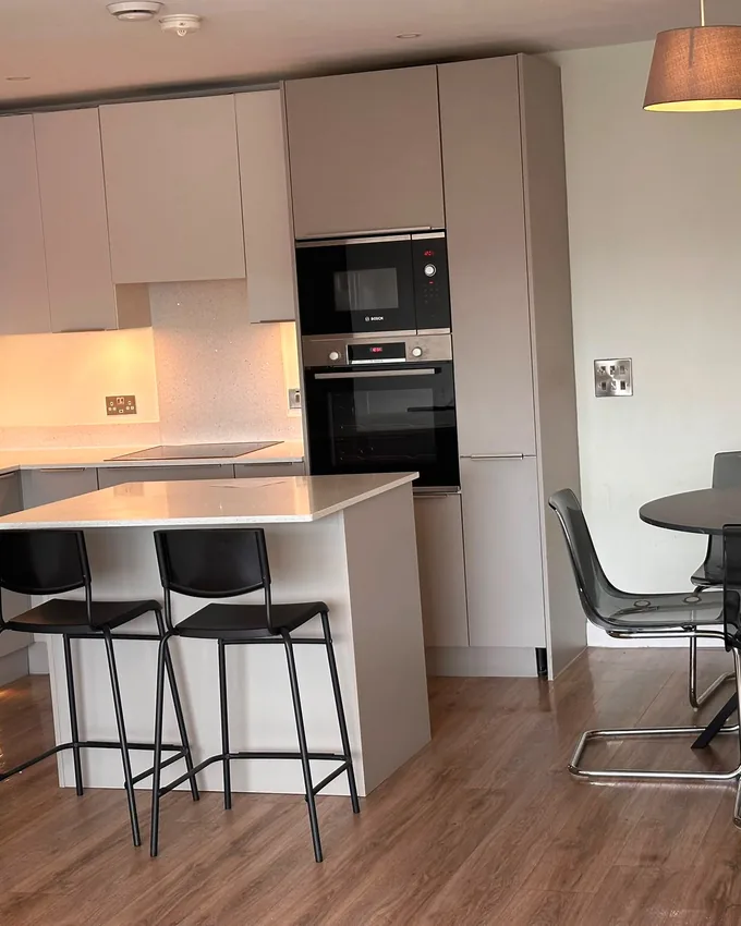 Modern kitchen with island and bar stools after a full clean